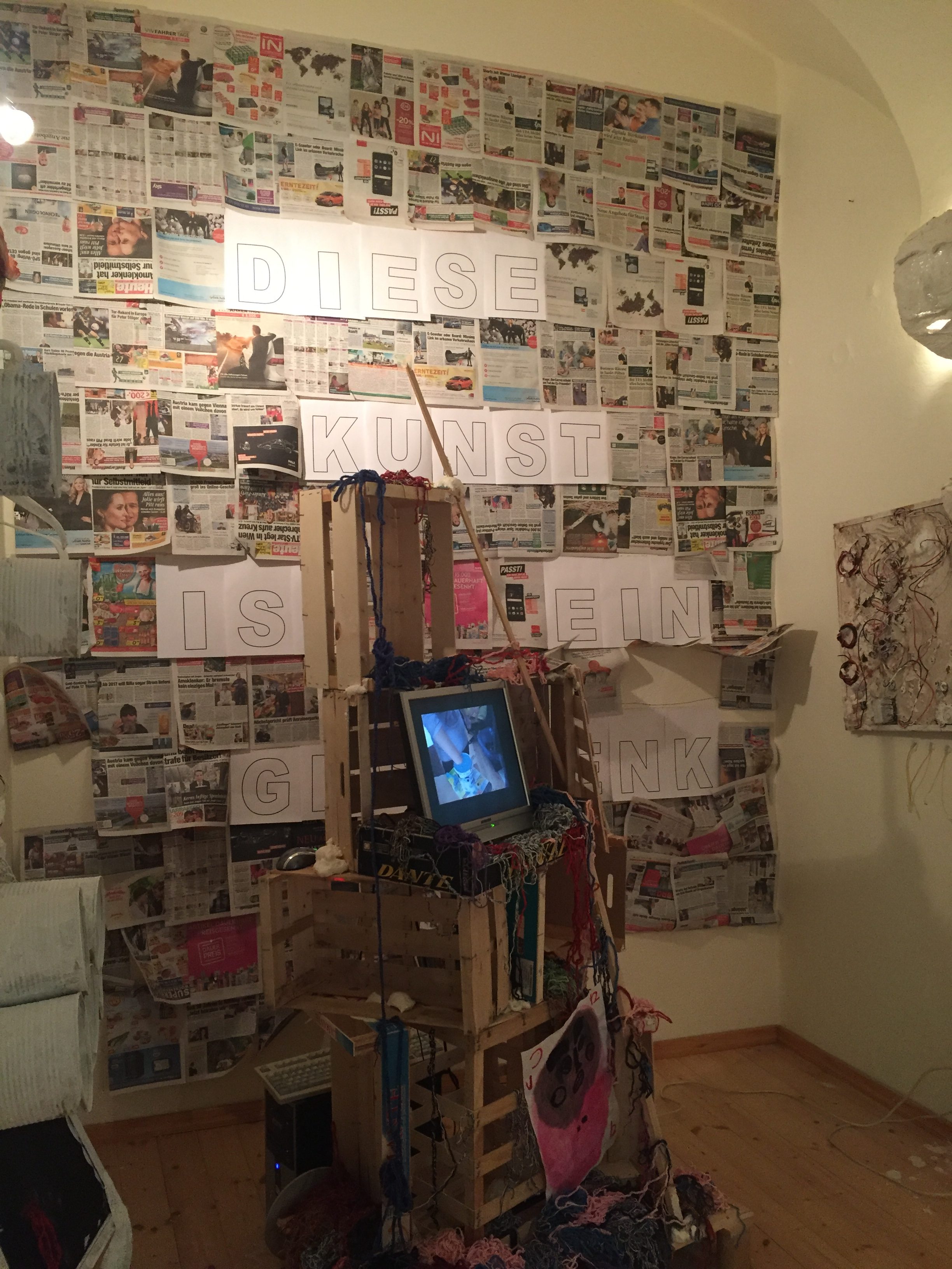 Foto JAW-Kunstaktion "Diese Kunst ist ein Geschenk" Collage mit Zeitungen, Holzkisten, Wolle und Laptop